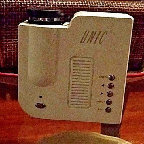white small unic projector with tri pod