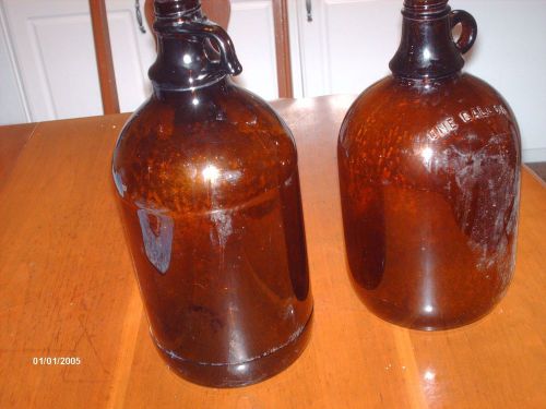 TWO AMBER GALLON  JUGS WITH HANDLE MEASURING APPROXIATELY 14&#034; TALL &amp; 12&#034; TALL