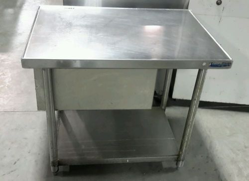 Used stainless steel commercial work table with tray storage for sale