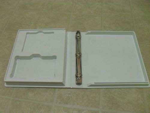 White plastic binder with space for VHS tape and an other space for small manual
