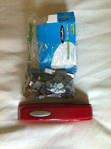 red stapler with a bunch of staples 