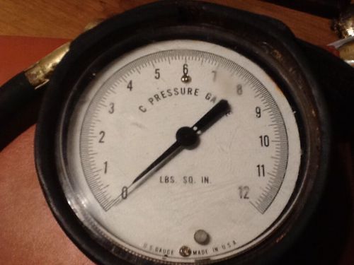 A vintage pressure gauge 1-12 lbs. With leather shoulder strap.