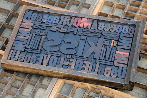Collage &#034;KISS&#034; made of letterpress wood type characters in antique drawer old