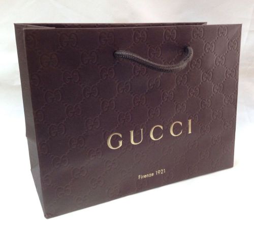 Embossed paper shopping bag from Gucci designer store. Brown,gold logo